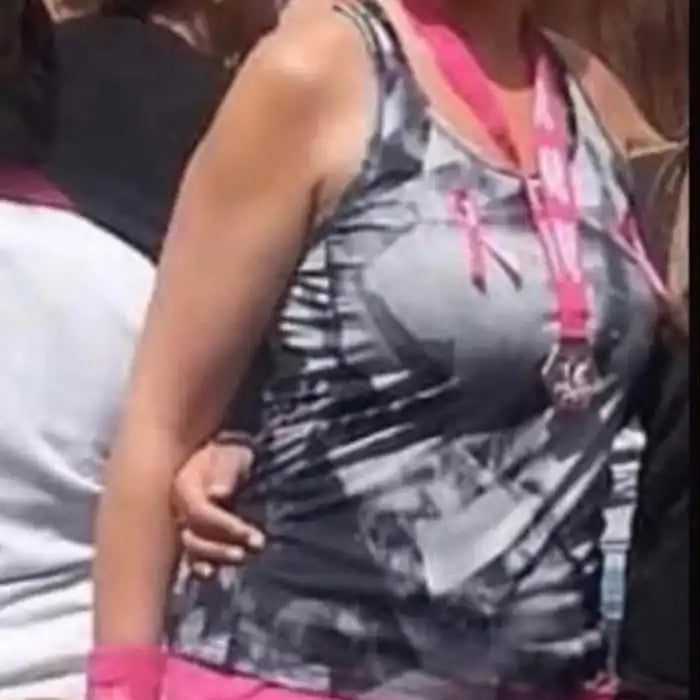 Grijze en zwarte gestreepte tanktop met roze lint en medaille.