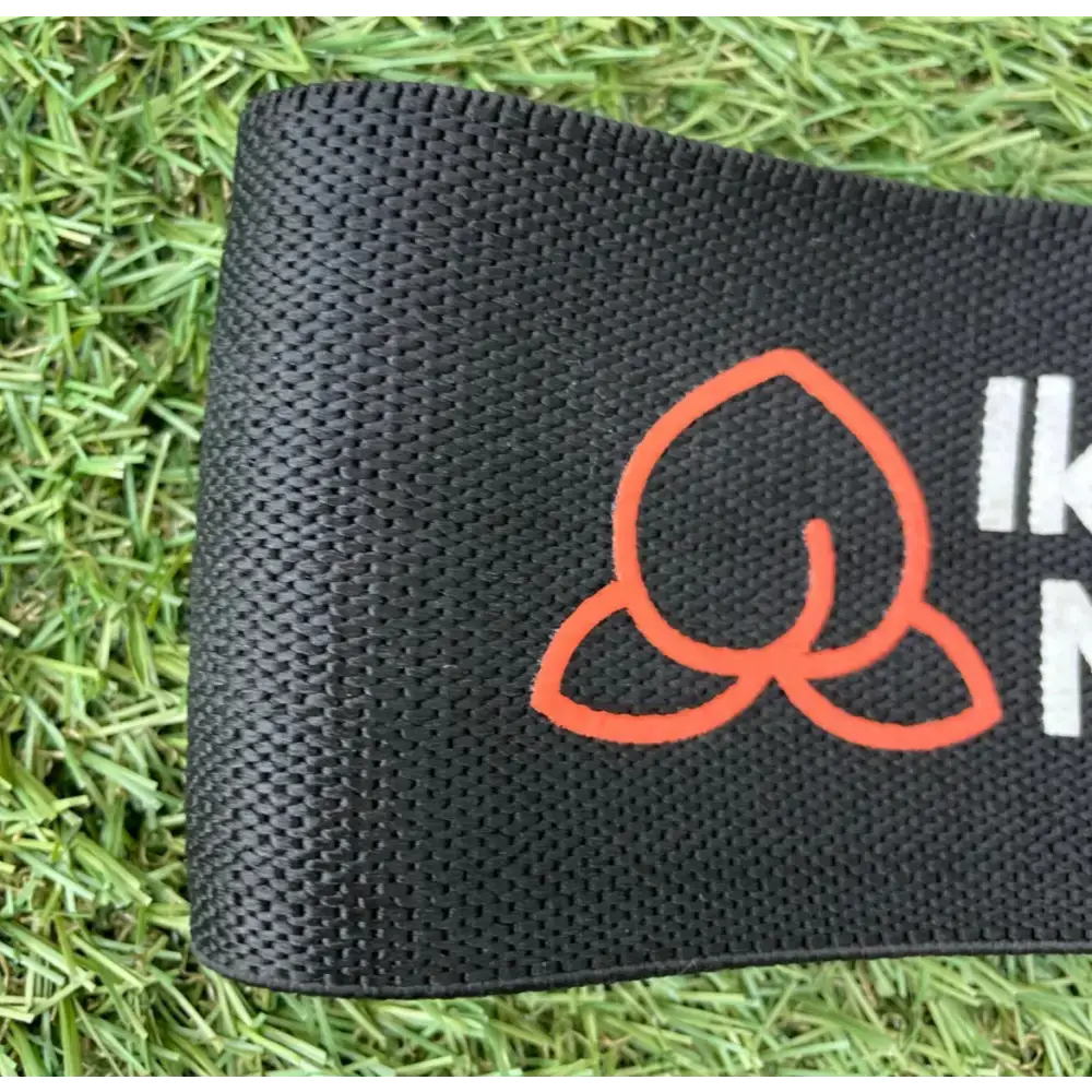 Zwarte verstelbare booty band met oranje ontwerp en zwarte woven label